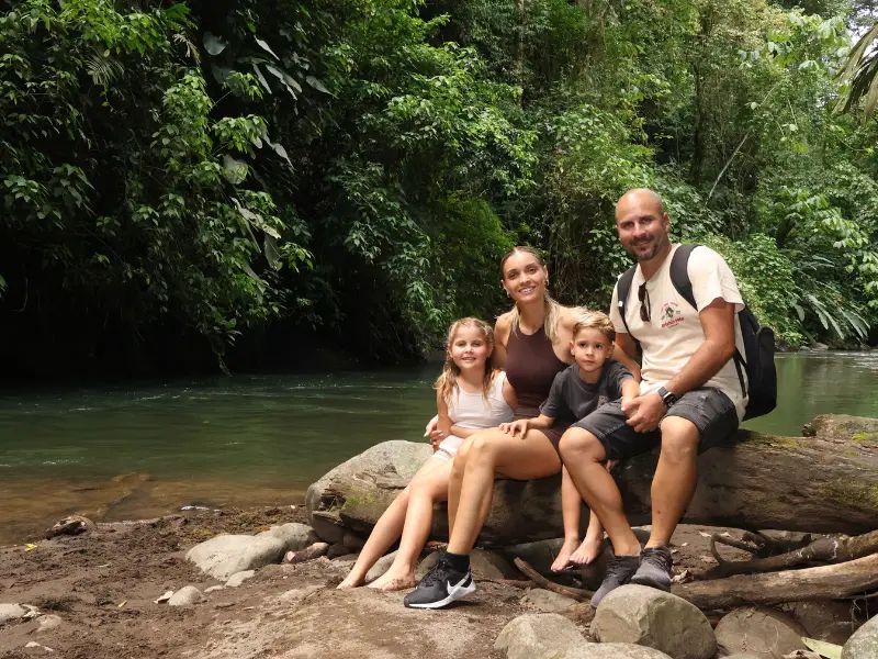 Family relaxing by the river after an ATV adventure tour in La Fortuna, Costa Rica