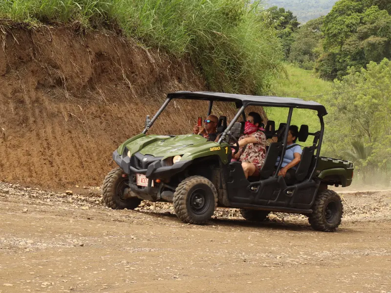 Group riding a Side by Side UTV on dirt trails with Arenal Volcano views in La Fortuna