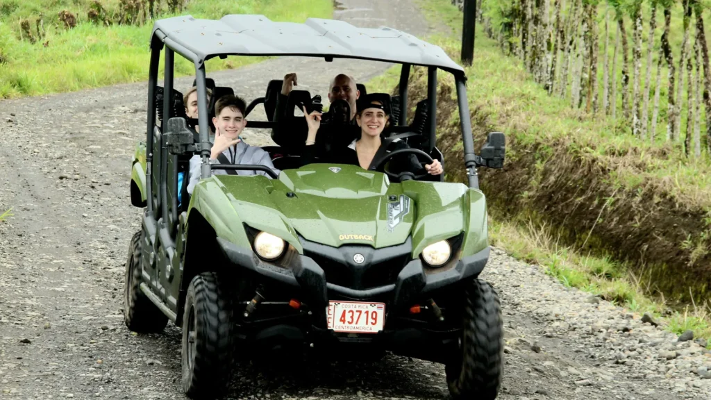 Family riding a side-by-side vehicle on a rural road near La Fortuna, Costa Rica.