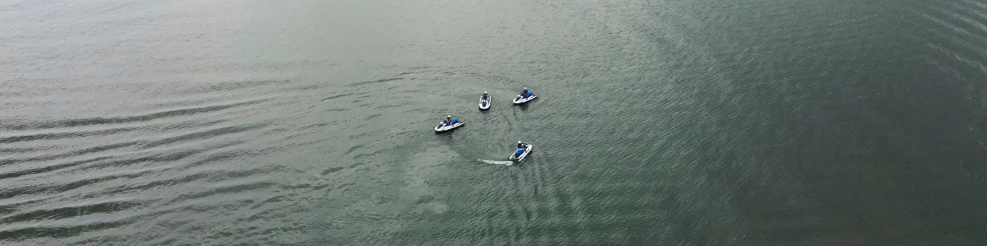 Group of jet skis riding on Lake Arenal in La Fortuna Costa Rica with aerial view of the water.