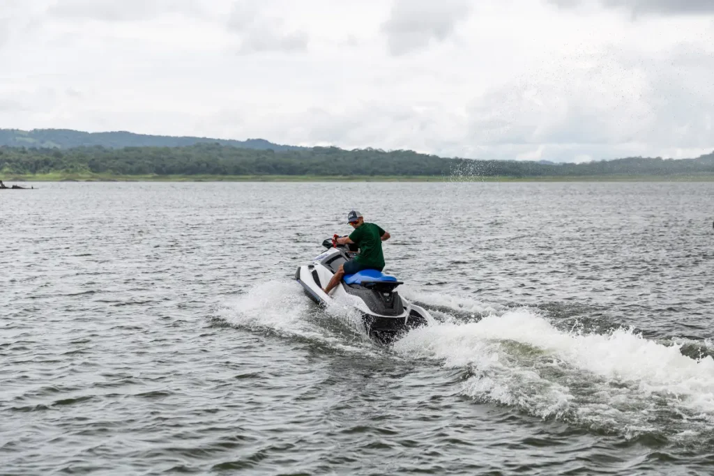 Person riding a jet ski across Lake Arenal with scenic views in La Fortuna, Costa Rica.