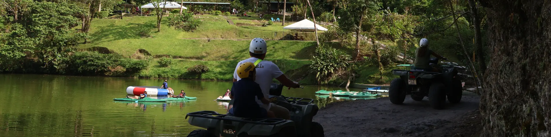 Travelers riding ATVs near a scenic lake during a guided tour in La Fortuna, Costa Rica.