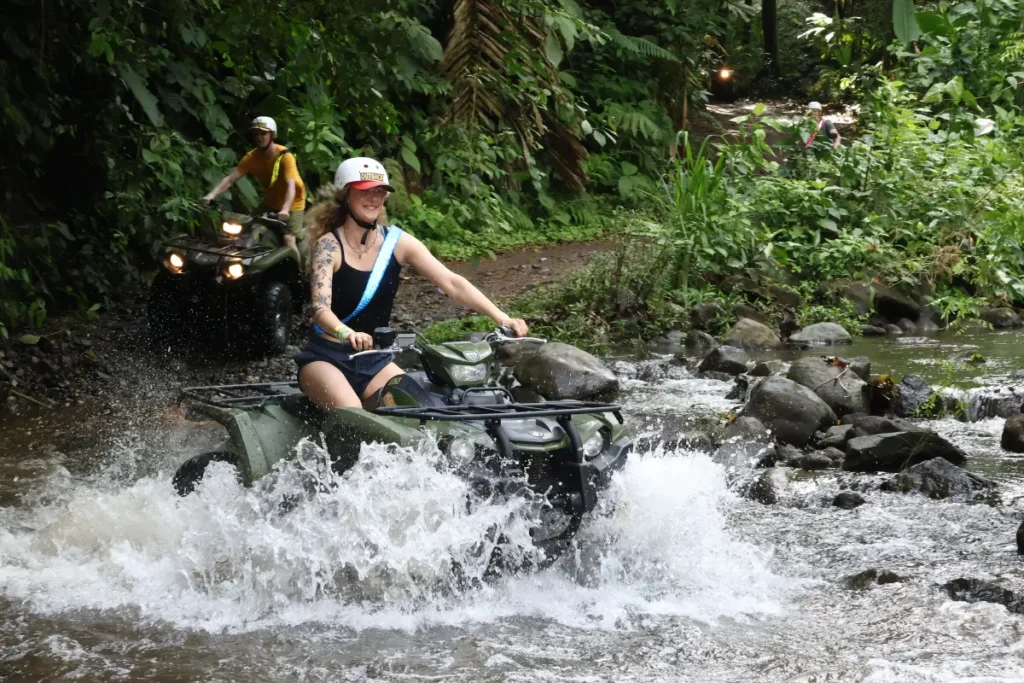 Woman riding an ATV through a river during a discovery tour in La Fortuna Costa Rica.